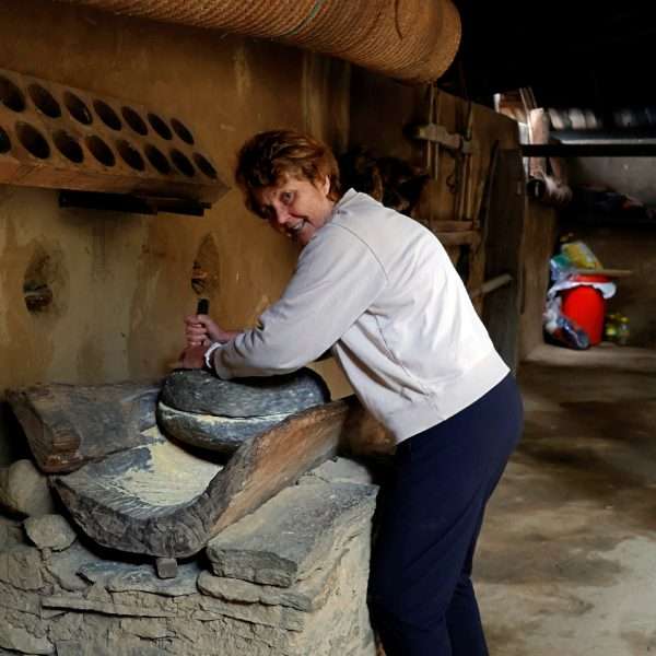 Couple from Australia trying traditional wheat grinding